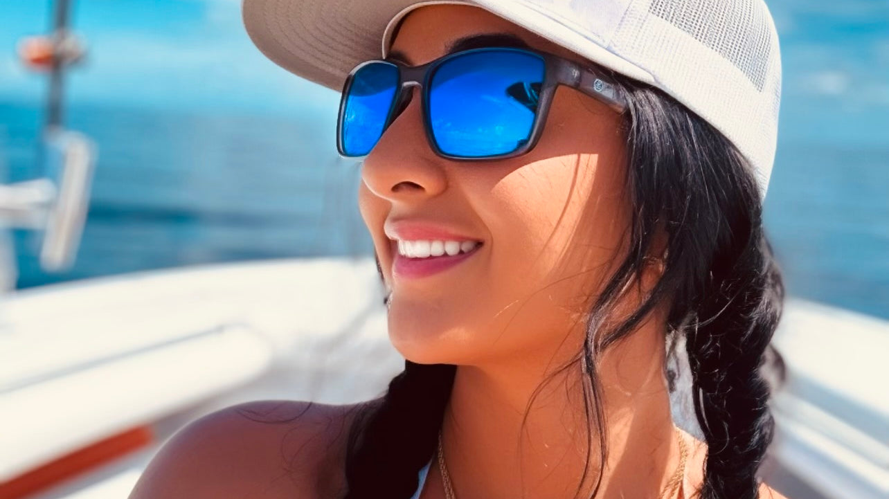 Angler wearing polarized fishing sunglasses, focusing on a clear view of the water while casting a fishing rod on a sunny day.